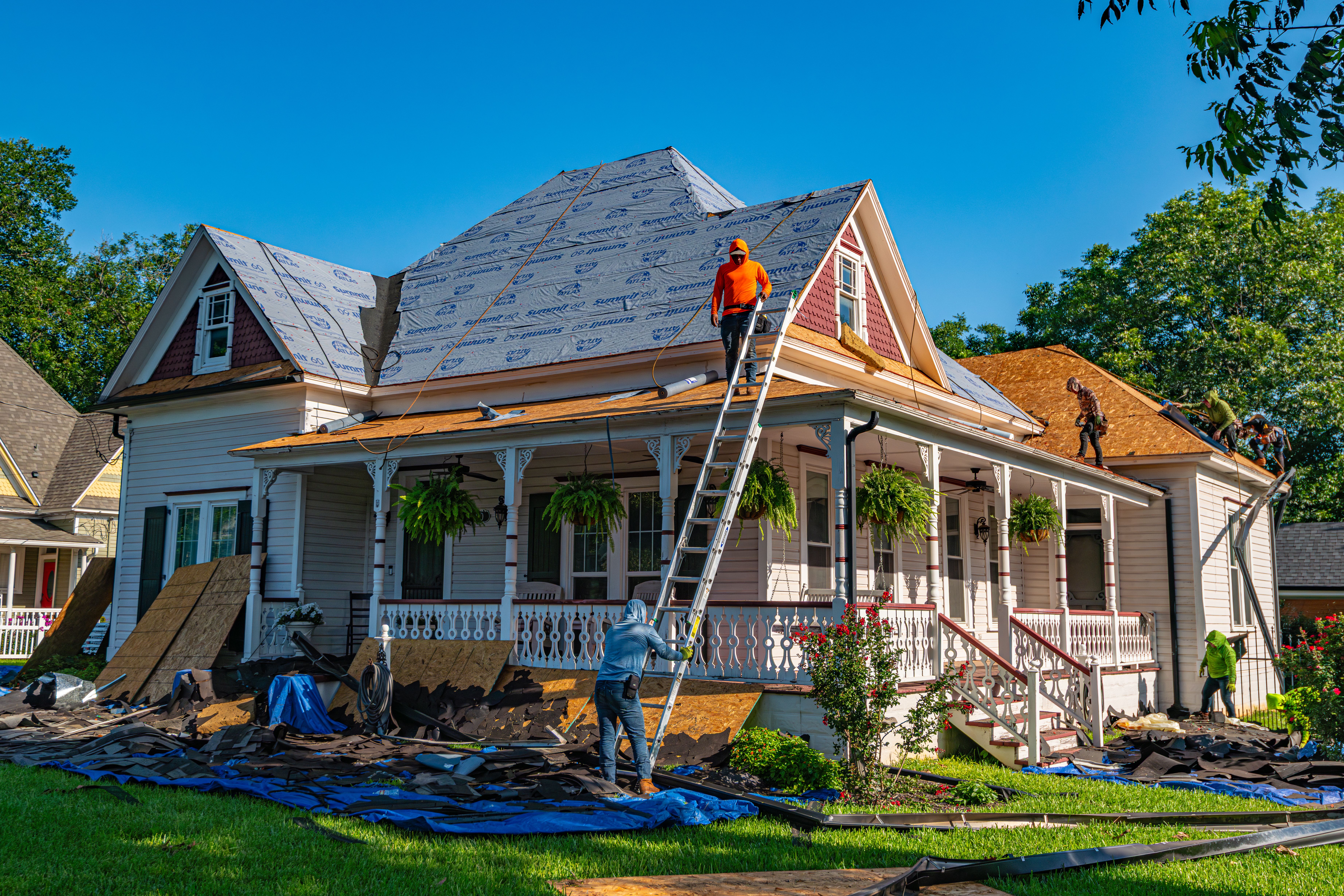 A roofing crew performing a full residential roof replacement
